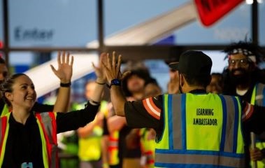 a learning ambassador high-fiving an area manager