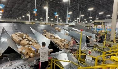 four associates sorting packages on top of the sort slide